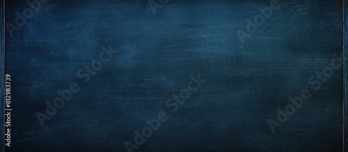 A dark blue chalkboard with traces of erasing featuring a full surface frame and a textured background Copy space image