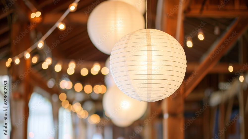 White Chinese paper lanterns hung in a barn as diy wedding reception decor. White Chinese paper lanterns hung in a barn as diy wedding reception decor.