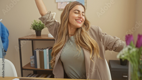 Joyful woman stretching in a modern office during a break, evoking happiness and a relaxed work environment. photo