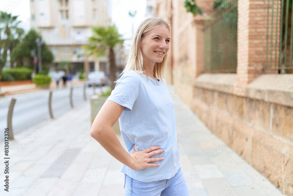 Young blonde woman smiling confident looking to the side at street Young blonde woman smiling confident looking to the side at street