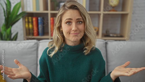 Photos A perplexed blonde woman indoors with a neutral home background featuring a bookshelf and a houseplant