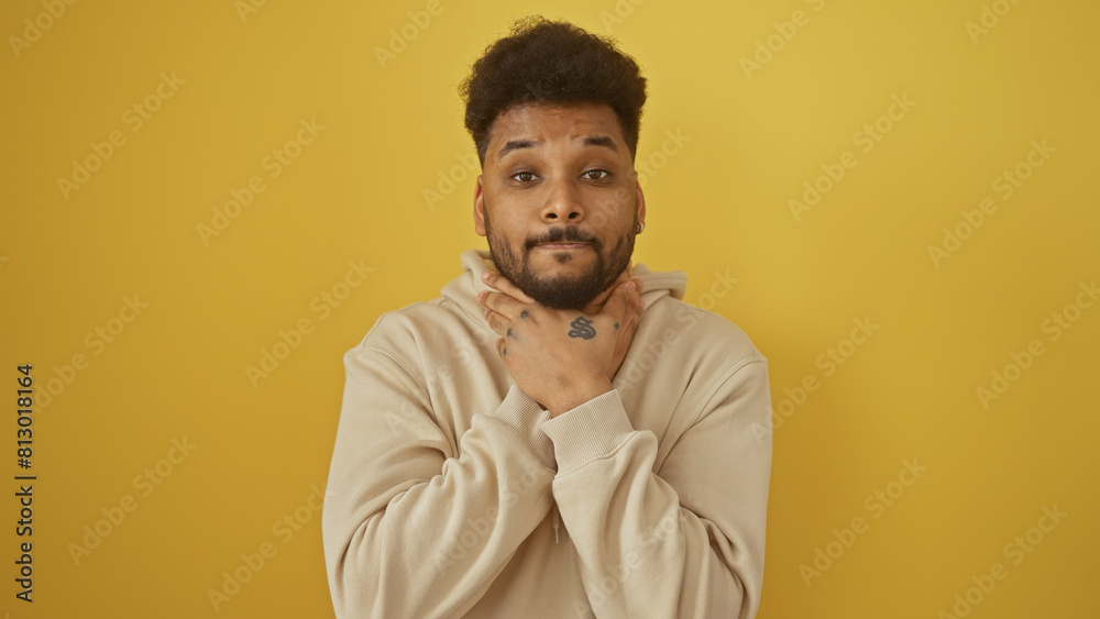 Obraz premium Portrait of a stylish adult man posing confidently against a solid yellow background