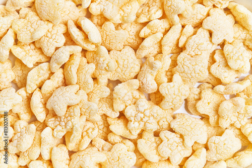 Close-up of yellow rice crackers against a white background with ample texture. photo