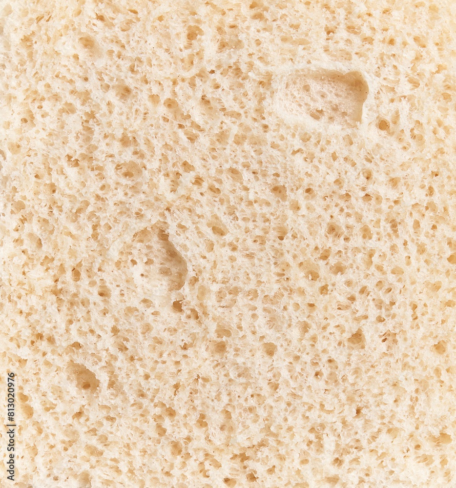 Closeup texture of a porous beige bread slice, symbolizing bakery, food, and nutrition.