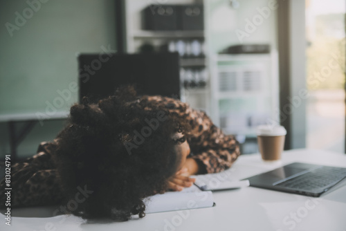 фотографія Young woman her head at office desk in front of laptop, feeling ruined, suffer f