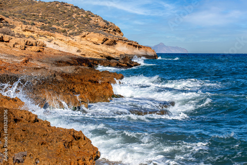 Rugged, rocky coast with surf in Cabo Cope and Puntas de Calnegre Regional Park, Murcia, Spain, in daylight photo