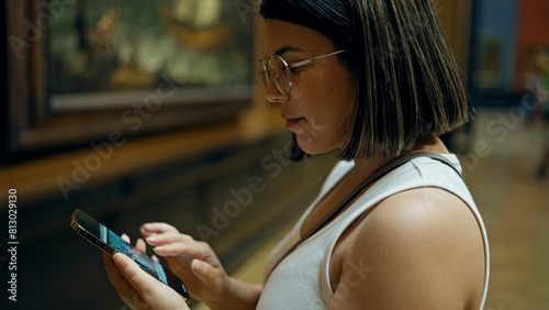 Photography Young beautiful hispanic woman visiting art gallery using smartphone at Art Muse