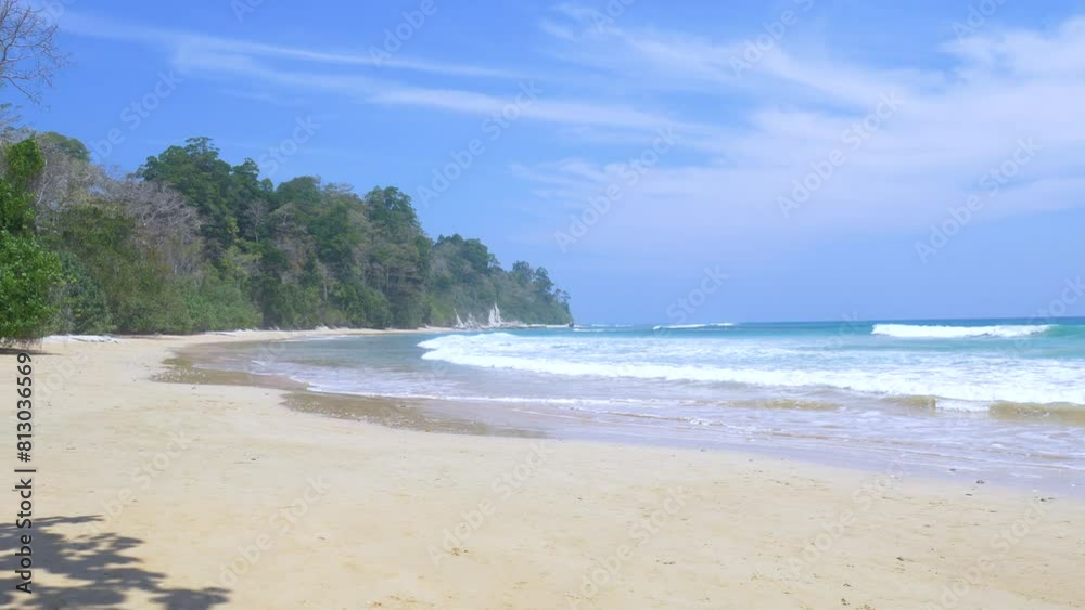 Crystal clear water lapping on tropical beach in the andaman islands. Turquoise water lapping gently on a pristine sandy beach with green jungle in the background Crystal clear water lapping on tropical beach in the andaman islands. Turquoise water lapping gently on a pristine sandy beach with green jungle in the background
