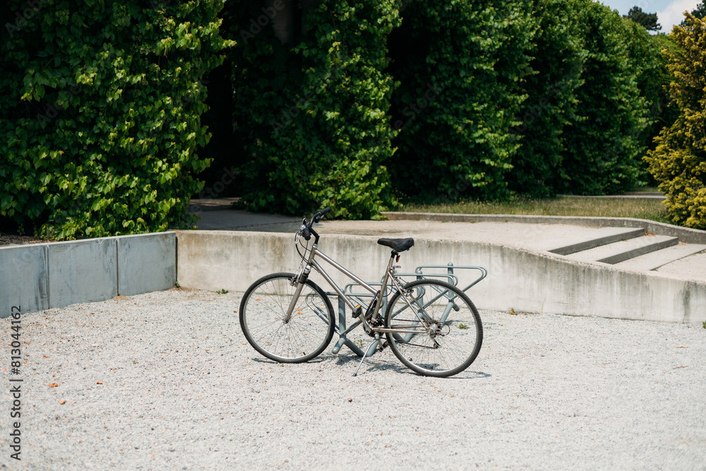 Fototapeta premium Locked bicycle at bicycle parking. Transport, storage and vehicle concept. Green pergola in Park