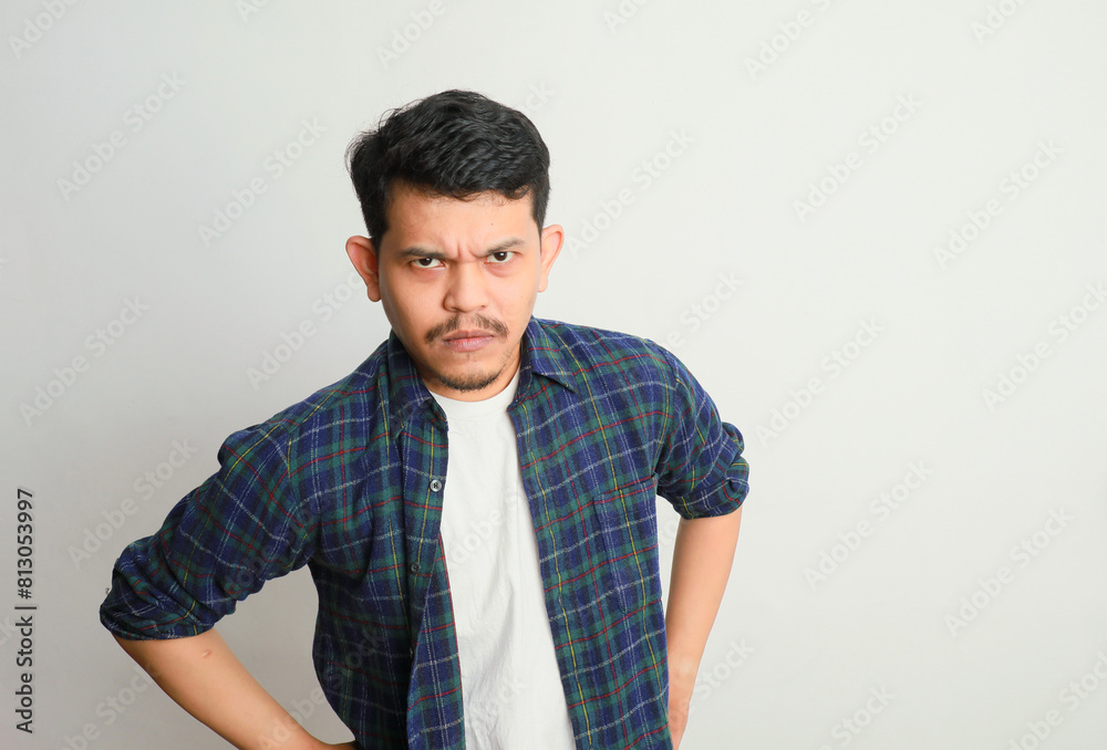 portrait of a young asian man showing a sullen and disappointed expression, isolated on a white background