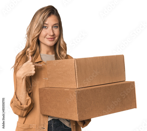 Blonde Caucasian moving with large boxes person pointing by hand to a shirt copy space, proud and confident photo