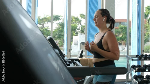 Wallpaper Mural Tired young woman wipes herself with a towel while jogging on treadmill at a gym, slow motion.  Torontodigital.ca