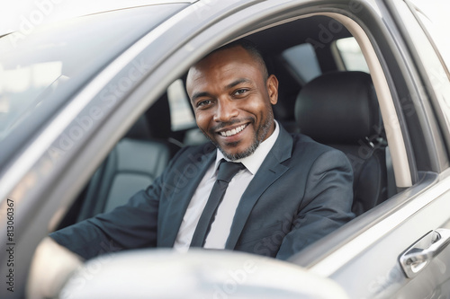 African taxi driver man in a suit and tie smiles while driving a car, private driver. Transportation of people concept