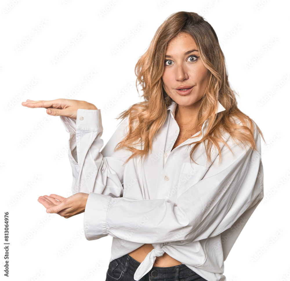 Caucasian blonde woman in studio shocked and amazed holding a copy space between hands. Caucasian blonde woman in studio shocked and amazed holding a copy space between hands.
