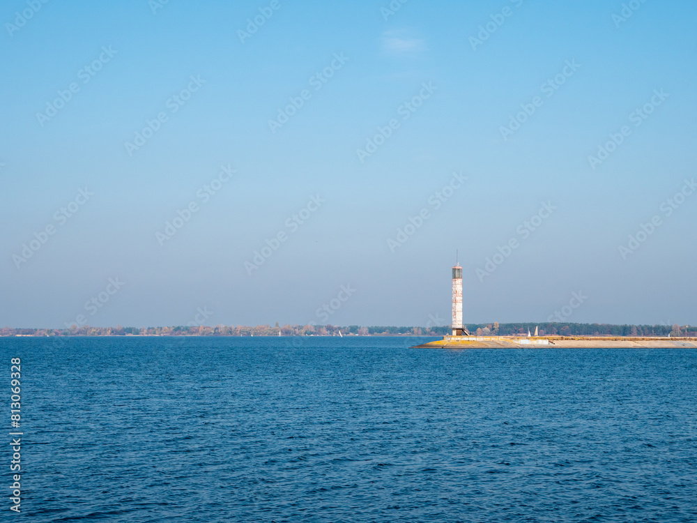 Beautiful blue Kyiv Cistern with the high white lighthouse on a concrete bar. Beautiful blue Kyiv Cistern with the high white lighthouse on a concrete bar.