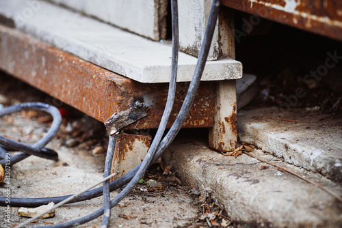 Rusty Iron in Vintage Construction Setting. Electric welding machine negative cable It is welded to a steel frame. Unsafe no contacts, bare ends of wires, no clamps. The work is not safe and dangerous photo