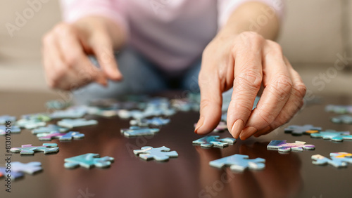 Memory training. Senior woman playing puzzle at home, closeup