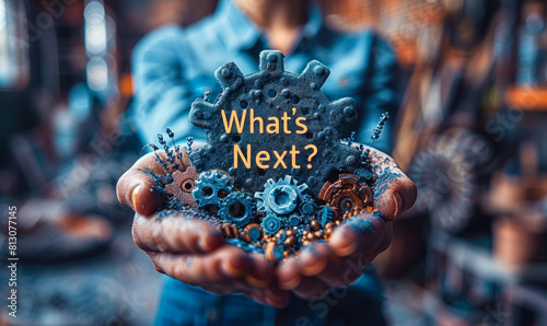 Person holds holographic icon depicting gears and the phrase What's Next? in their hands, representing the concept of innovation, progress, and exploring future possibilities in technology or business