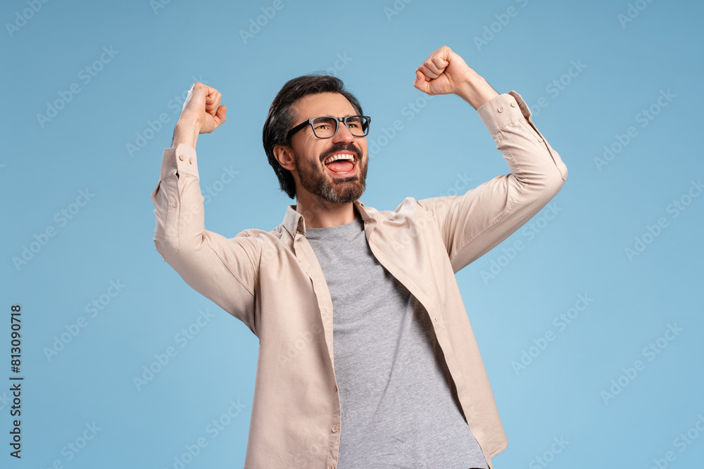 Naklejka premium Excited bearded man gesturing happiness isolated on blue background