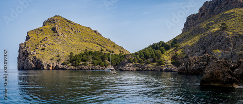 Morro de Sa Vaca peak, complemented by Coll des Bancalet and el Turmàs mountain, while a catamaran anchors in Sa Calobra bay, ideal for promoting leisurely boat trips and coastal tourism in Mallorca. photo