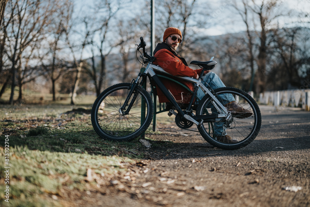 A person in casual attire enjoying a restful moment on a bicycle in a peaceful park setting. A person in casual attire enjoying a restful moment on a bicycle in a peaceful park setting.