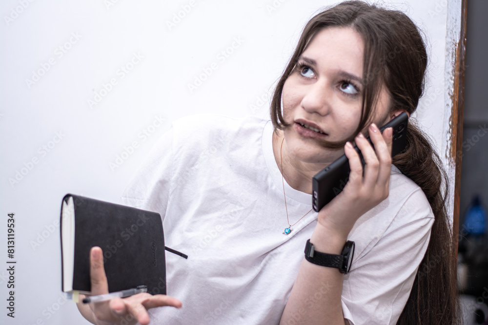 Business woman talking on phone holding notebook Business woman talking on phone holding notebook