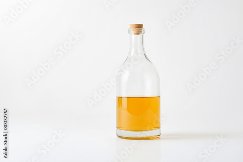 Glass bottle filled with yellow liquid  on white background