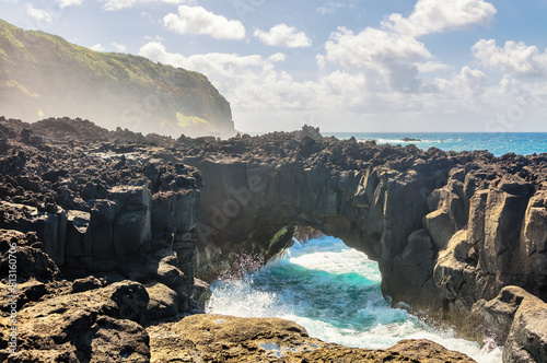 Atlantic ocean wave breaks on the big rocky stone on the beautiful beach of Sao Miguel island