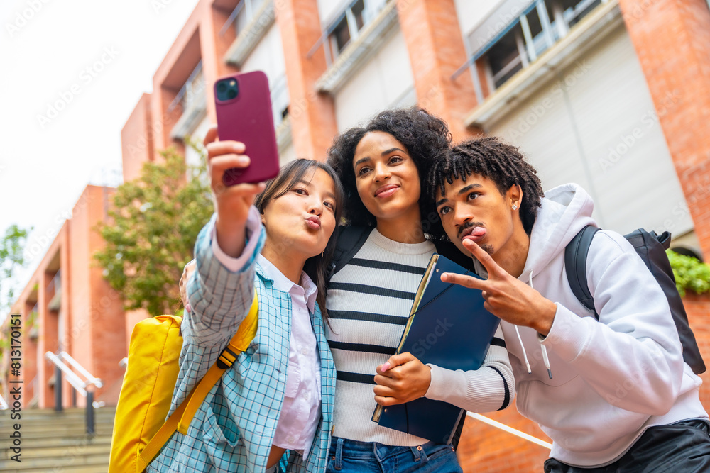 Obraz premium Happy multiracial university students taking a selfie outside the campus