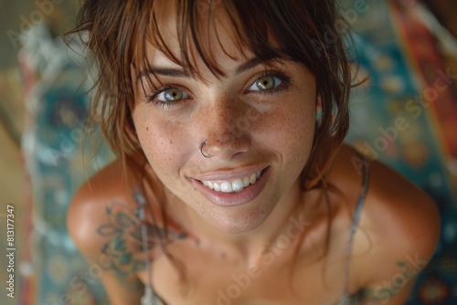 Close-up portrait of a smiling woman with sparkling green eyes and tattoos, exuding genuine warmth and spunky personality photo