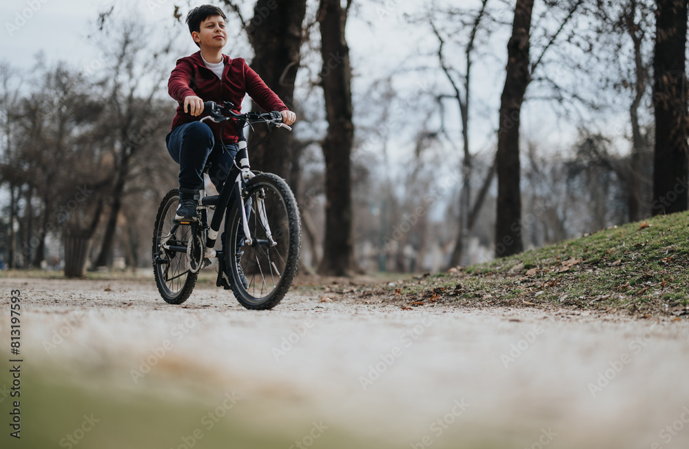 Carefree young boy rides his bicycle on a path in an urban park, exemplifying healthy childhood leisure and the joy of outdoor activities. Carefree young boy rides his bicycle on a path in an urban park, exemplifying healthy childhood leisure and the joy of outdoor activities.
