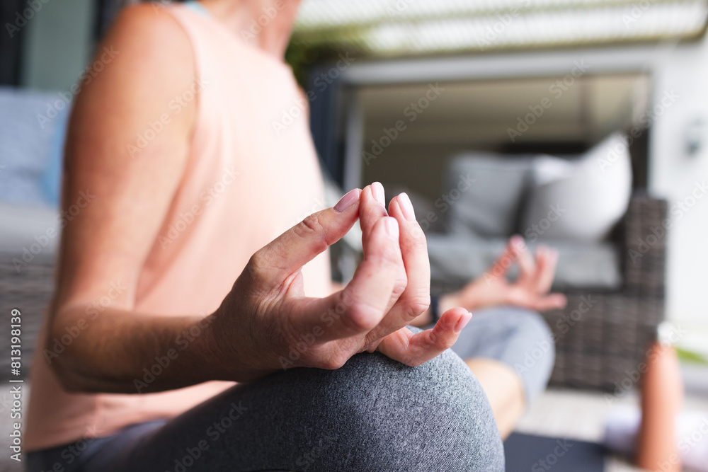 © Wavebreak Media - At home, mature Caucasian woman practicing yoga, focusing on hand position