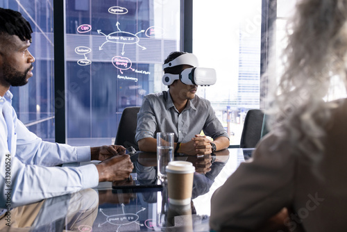 At office, diverse team at table, Asian man wearing VR headset photo
