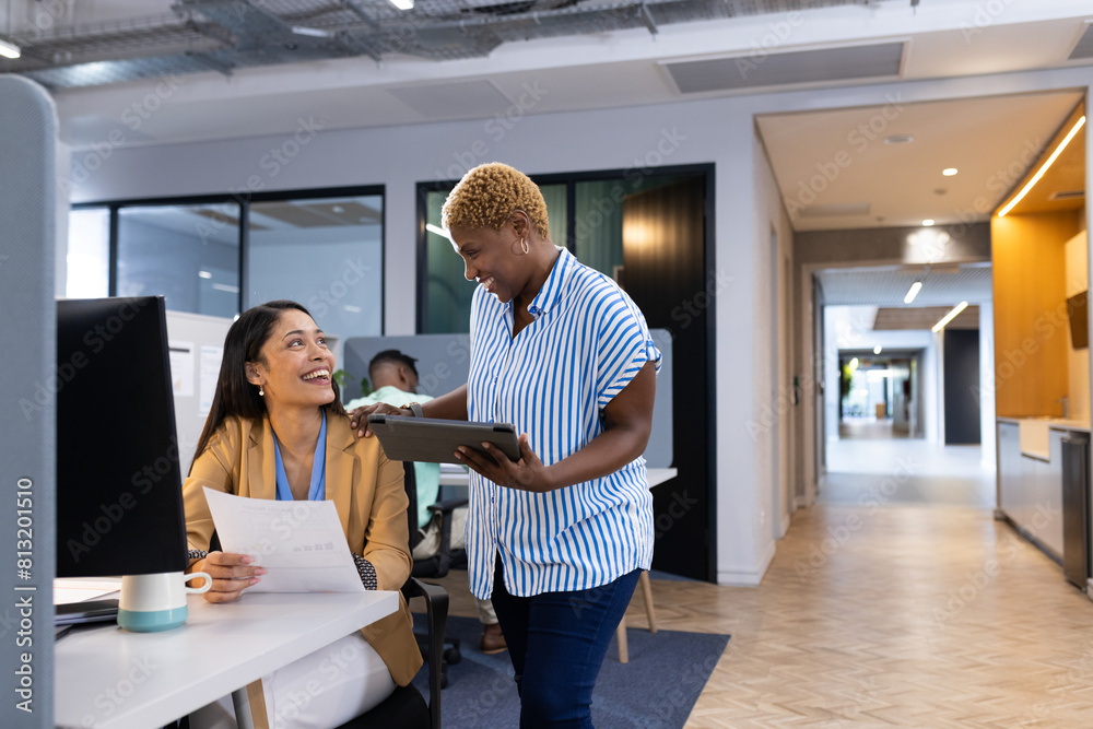 Diverse team discussing business documents at office, sharing happy moment Diverse team discussing business documents at office, sharing happy moment