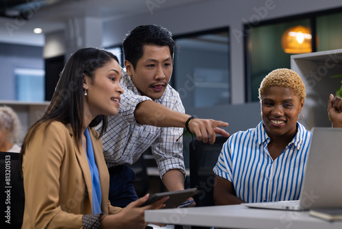 Office scene with diverse team: Asian man, African American woman, viewing screen photo