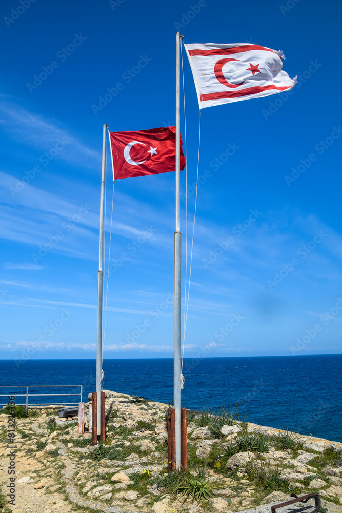 Fototapeta premium Turkey and Turkish Republic of Northern Cyprus flags waving in the blue and cloudy sky
