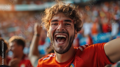 Cheerful fan in red t-shirt and glasses at stadium