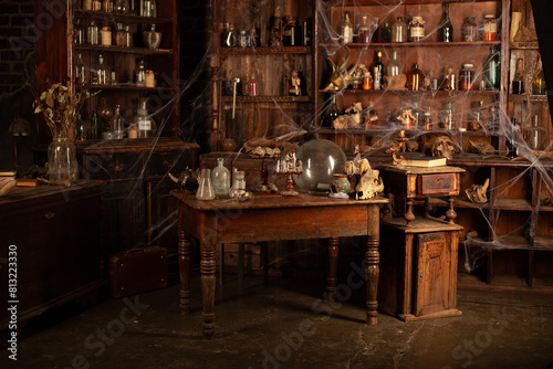 Halloween background Shelves with alchemy tools Skull spiderweb bottle with poison candles Witcher workspace Scarry room