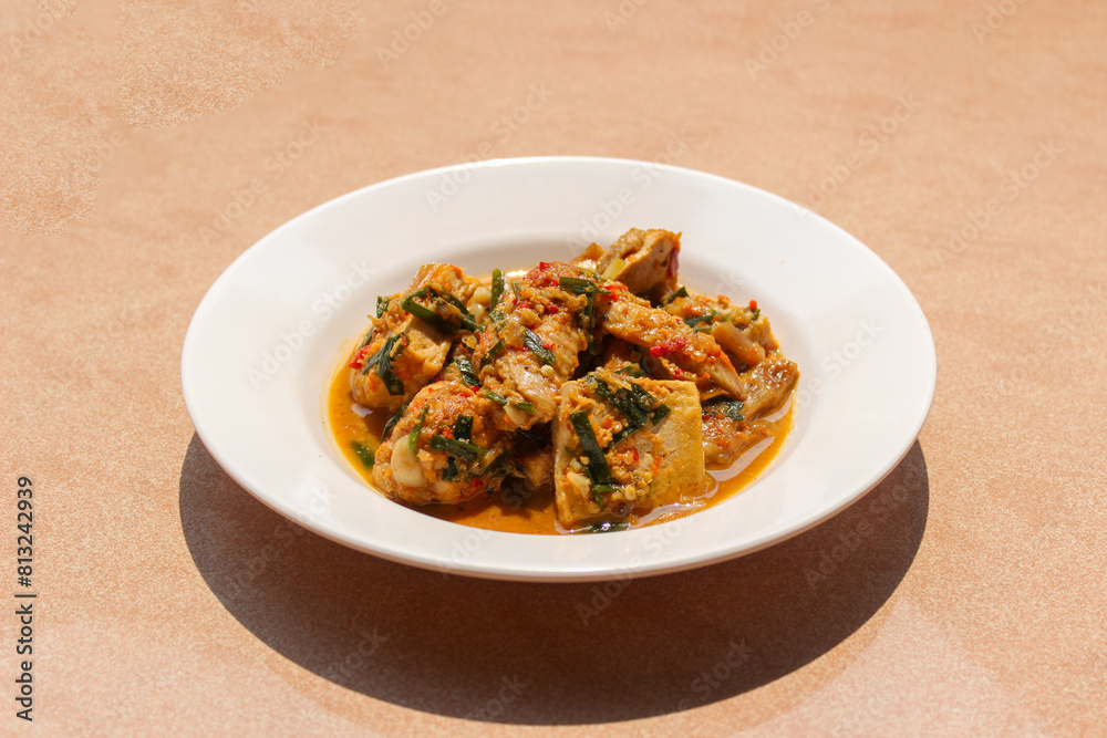 Ayam Rica Rica. Traditional dish from Manado, Indonesia, boiled chicken with the addition of tofu and using spicy spices and garnish served on a white plate Ayam Rica Rica. Traditional dish from Manado, Indonesia, boiled chicken with the addition of tofu and using spicy spices and garnish served on a white plate