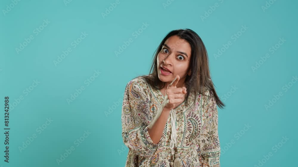 Irked indian woman fighting with boyfriend, doing scolding gesturing, isolated over studio background. Outraged wife arguing with husband during conversation, doing angry hand gestures, camera A