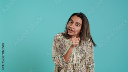 Irked indian woman fighting with boyfriend, doing scolding gesturing, isolated over studio background. Outraged wife arguing with husband during conversation, doing angry hand gestures, camera A photo