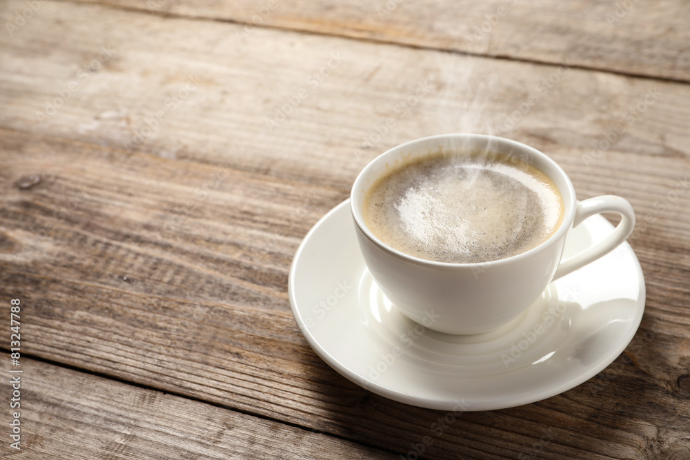 Steaming coffee in cup on wooden table. Space for text Steaming coffee in cup on wooden table. Space for text