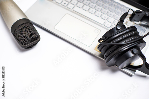 Studio microphone with studio headphones and laptop on white background