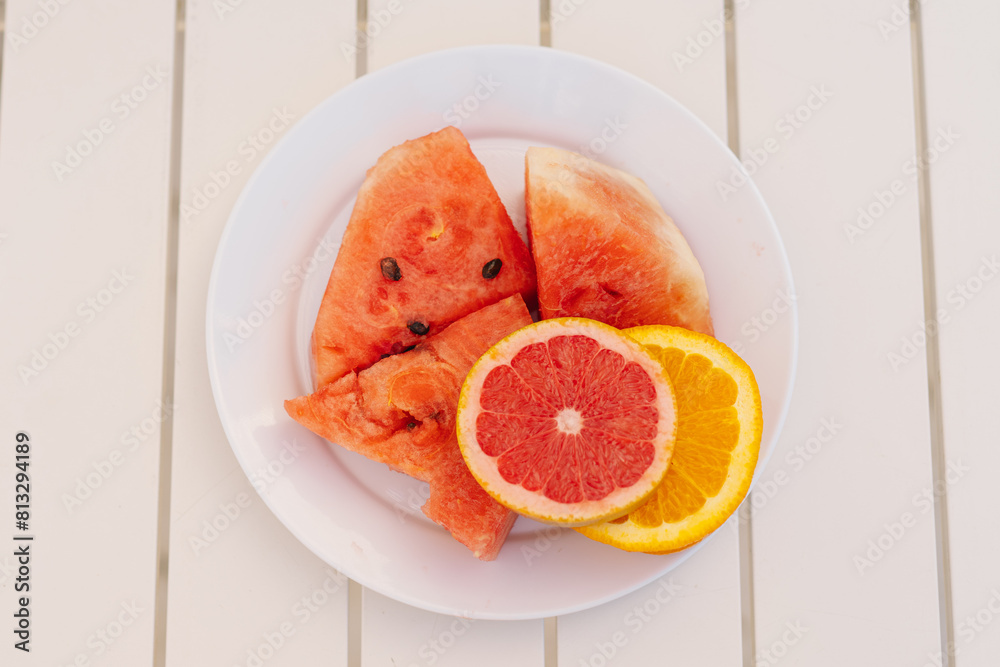 Sliced Watermelon and Citrus Fruits on a White Plate During a Sunny Day Sliced Watermelon and Citrus Fruits on a White Plate During a Sunny Day