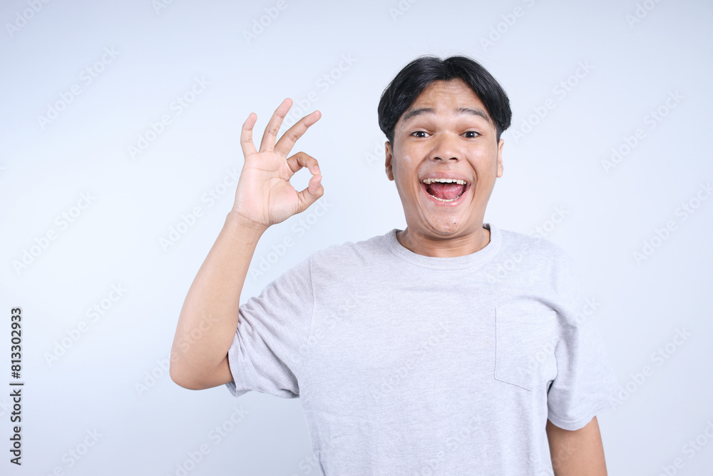 Cheerful Asian Young Man Showing Ok Sign Isolated On White Background Cheerful Asian Young Man Showing Ok Sign Isolated On White Background