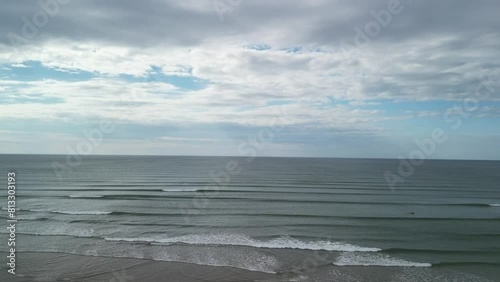 An aerial lift of over calm Atlantic Ocean with incoming waves in the morning. West Cork, Ireland. photo