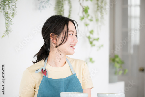Image of a customer service woman or housewife in an apron serving food in a café Welcome!