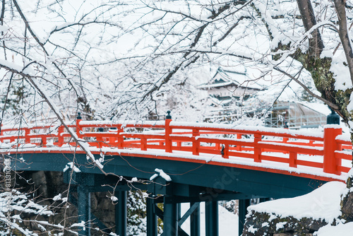 White Hirosaki Castle or Takaoka Castle and red bridge with snow in winter, hirayama style Japanese castle located in Hirosaki city, Aomori Prefecture, Tohoku, Japan. Landmark for tourist attraction photo