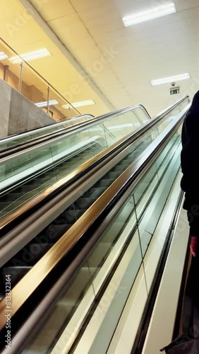 Moving up the escalator with glass sides and metal steps