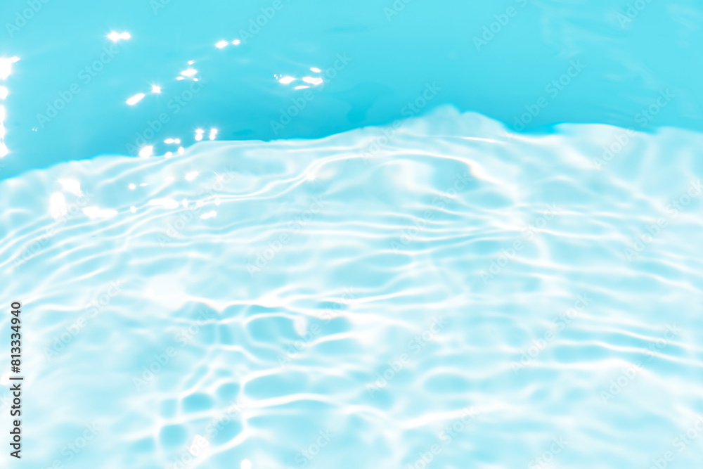 Obraz premium Blue water with ripples on the surface. Defocus blurred transparent blue colored clear calm water surface texture with splashes and bubbles. Water waves with shining pattern texture background.